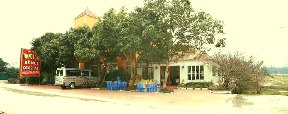 Nhà hàng Thăng Long Ninh Bình những năm trước: biển hiệu đỏ Dê núi – Cơm cháy bên đường, sân rộng, xe khách đỗ trước cửa